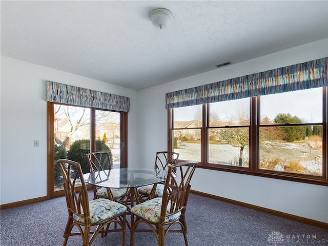 dining area with plenty of natural light and carpet