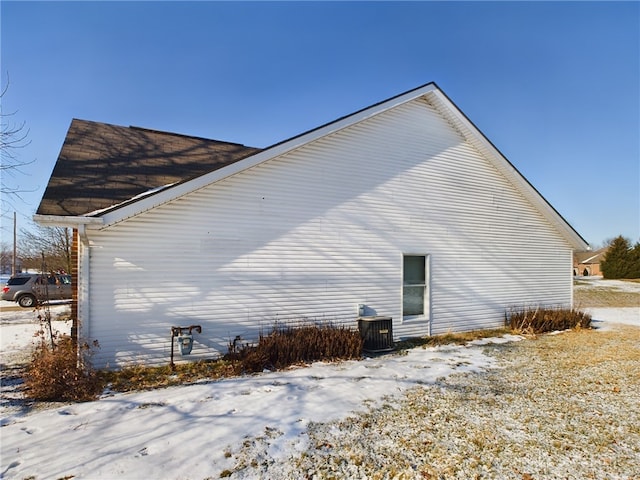 view of snowy exterior with central AC unit