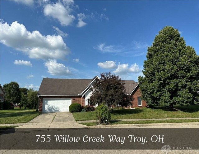 755 Willow Creek Way, Troy, OH 45373 - view of front of home with brick siding, a garage, a front yard, and concrete driveway