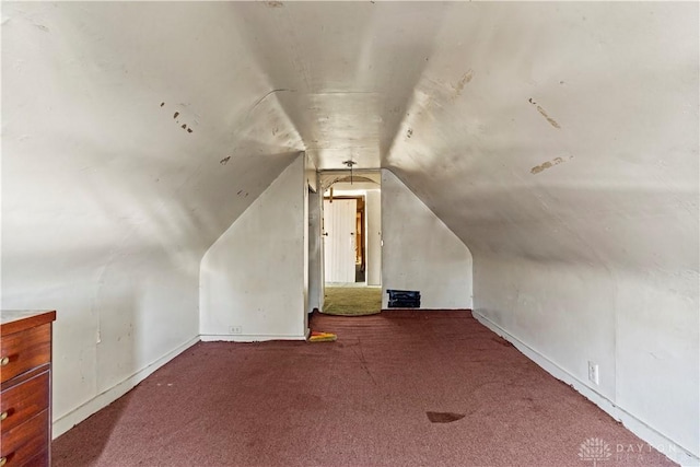 additional living space with carpet flooring and lofted ceiling