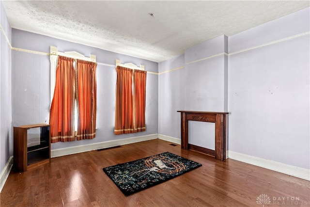 interior space with a textured ceiling and hardwood / wood-style flooring