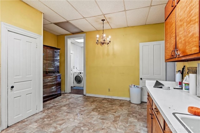 laundry room with washer / clothes dryer, sink, and an inviting chandelier