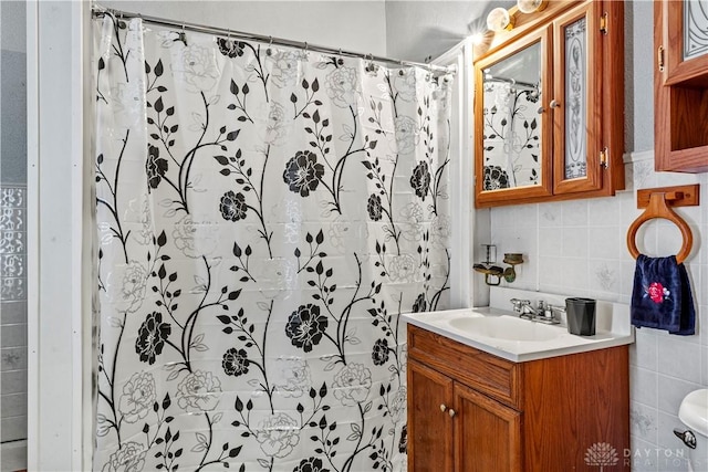 bathroom featuring vanity, backsplash, tile walls, toilet, and a shower with shower curtain