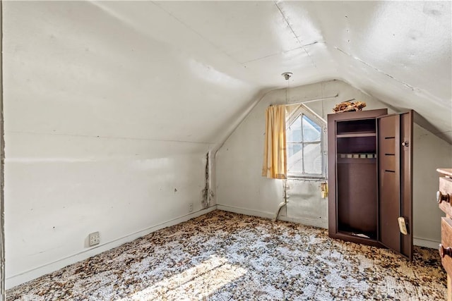 additional living space with light colored carpet and vaulted ceiling