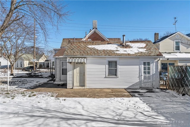 view of snow covered rear of property