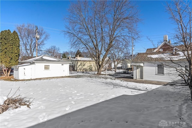 yard layered in snow with an outdoor structure