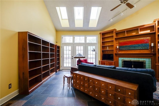 interior space featuring ceiling fan, high vaulted ceiling, and a skylight