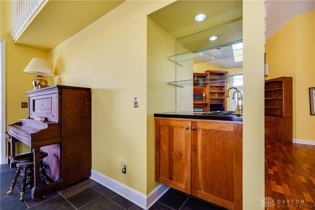 bar featuring dark tile patterned floors and sink