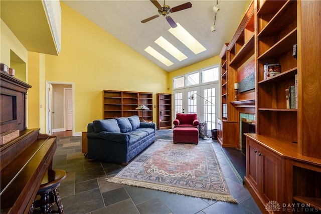 sitting room with high vaulted ceiling, french doors, a skylight, and ceiling fan