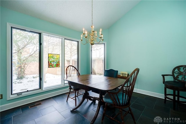 dining room featuring a textured ceiling, an inviting chandelier, and vaulted ceiling