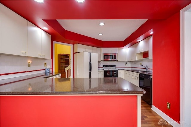 kitchen featuring electric range oven, dishwasher, kitchen peninsula, and white fridge