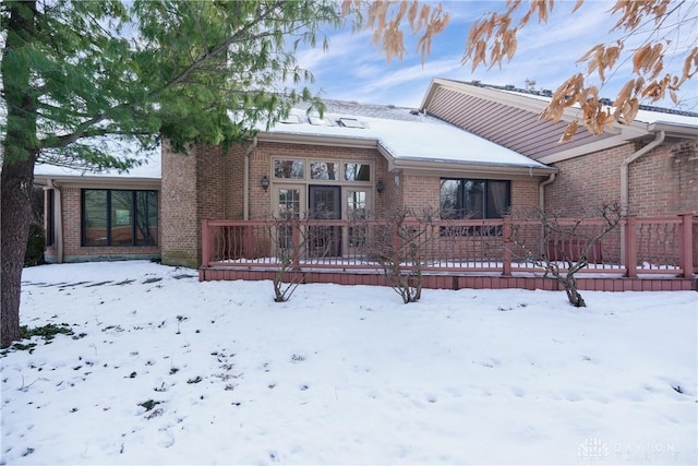 view of snow covered back of property