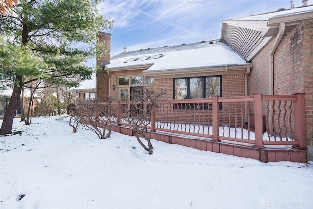 snow covered house with a wooden deck