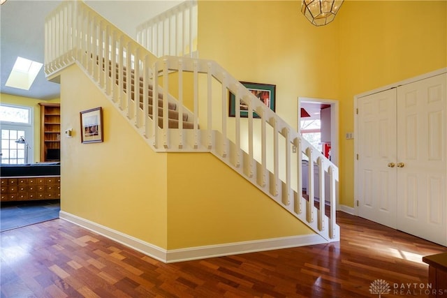 stairs with a skylight and hardwood / wood-style floors