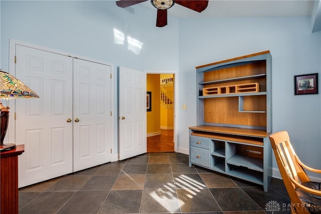 office space with ceiling fan, built in shelves, and high vaulted ceiling