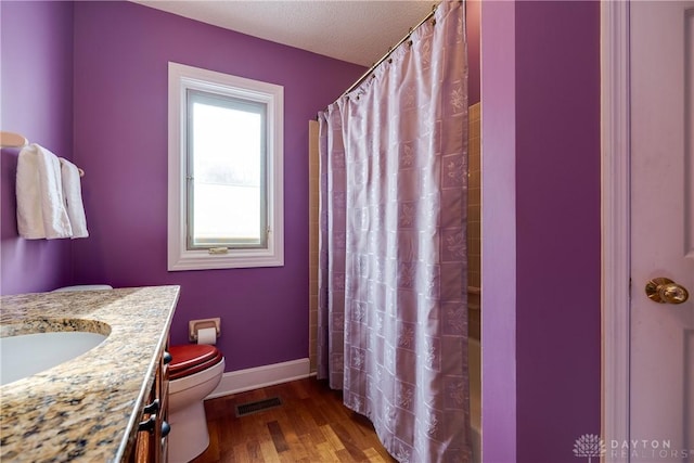 bathroom with toilet, hardwood / wood-style flooring, and vanity