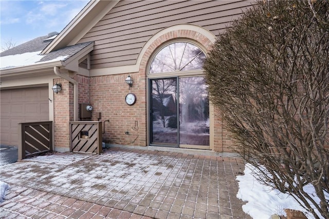 snow covered patio featuring a garage