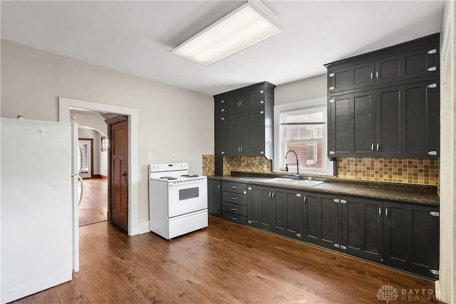 kitchen featuring decorative backsplash, dark wood-type flooring, sink, and white appliances