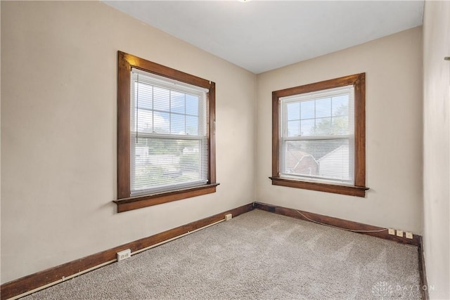 unfurnished room featuring a healthy amount of sunlight and carpet floors