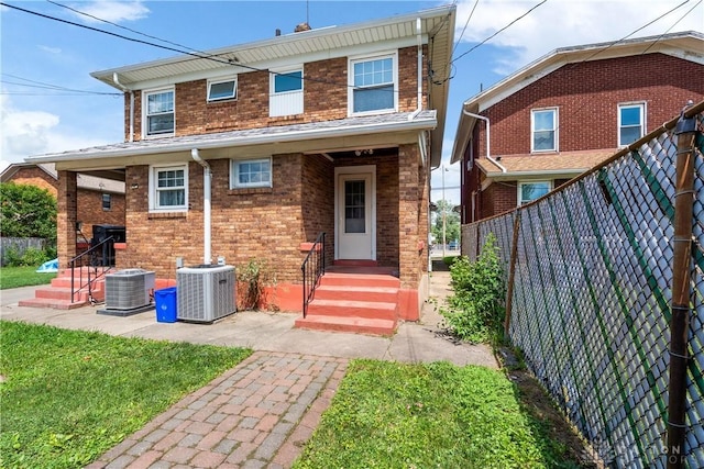 back of property featuring central AC unit and a yard