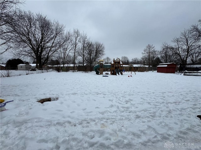 snowy yard featuring a playground