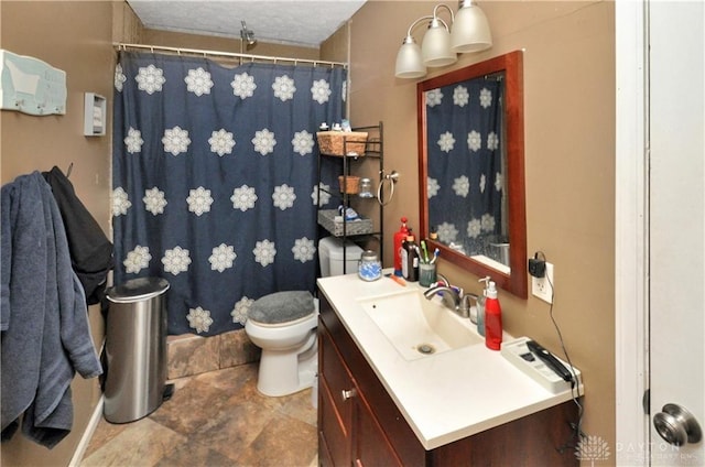 bathroom with vanity, toilet, and a textured ceiling