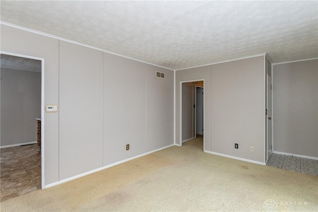 carpeted spare room featuring a textured ceiling