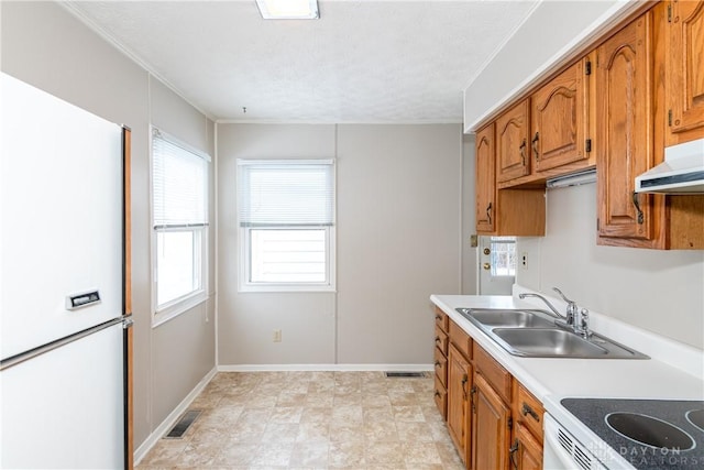 kitchen featuring sink, white appliances, and a textured ceiling