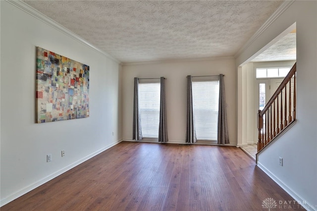 unfurnished room featuring dark wood-type flooring, a wealth of natural light, and a textured ceiling