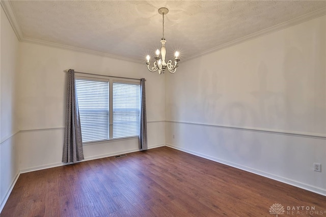 empty room featuring baseboards, dark wood finished floors, crown molding, a textured ceiling, and a notable chandelier