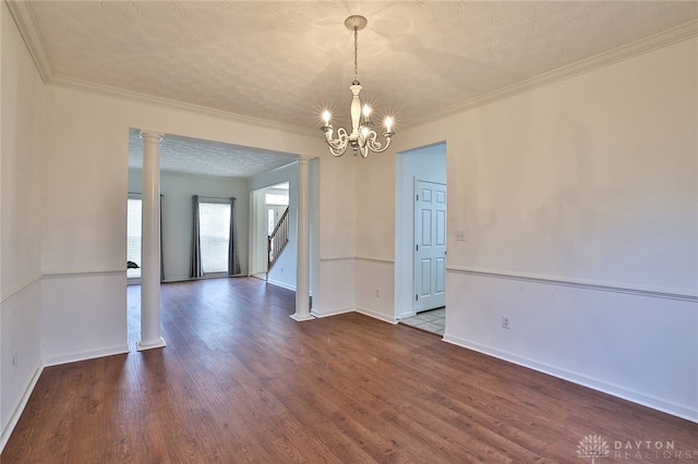 spare room featuring crown molding, decorative columns, stairway, a textured ceiling, and wood finished floors