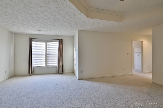 spare room featuring light carpet, visible vents, baseboards, and a textured ceiling