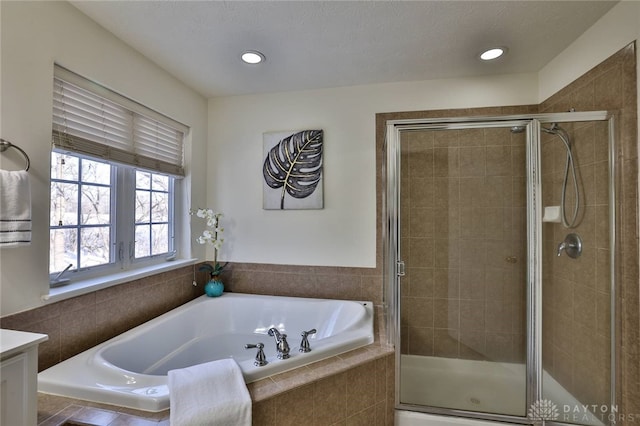 bathroom featuring a stall shower, vanity, and a bath