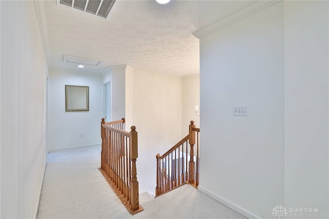 corridor featuring visible vents, light colored carpet, an upstairs landing, and attic access