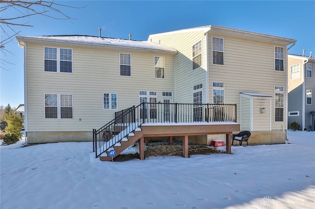 snow covered property with stairs and a wooden deck