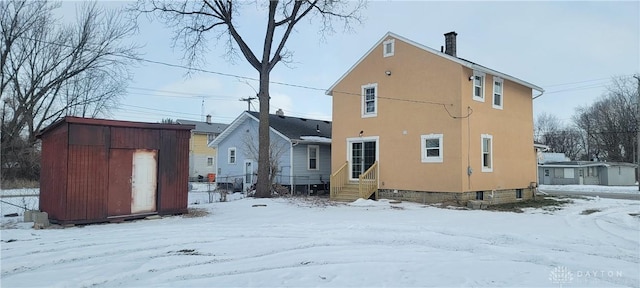 view of snow covered back of property