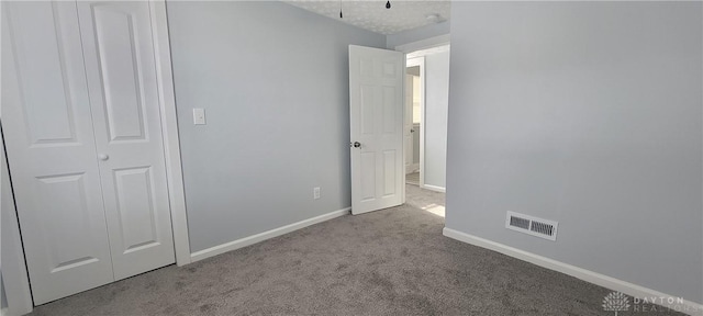 unfurnished bedroom with light carpet and a closet