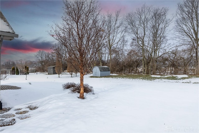 yard layered in snow with a storage unit