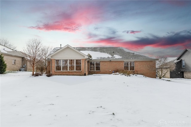 snow covered house featuring cooling unit