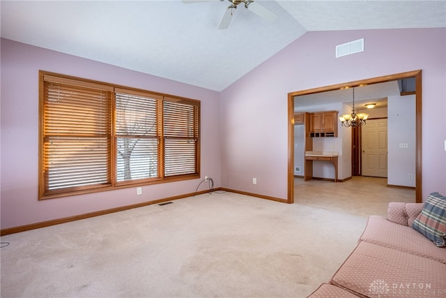 unfurnished living room with vaulted ceiling, ceiling fan with notable chandelier, and light carpet