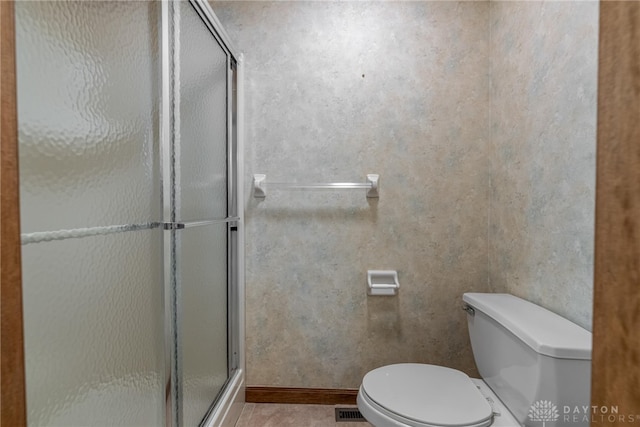 bathroom featuring toilet and walk in shower