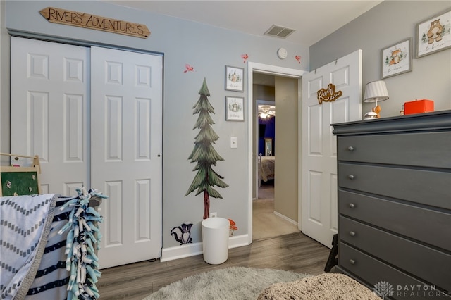 bedroom with dark hardwood / wood-style floors and a closet