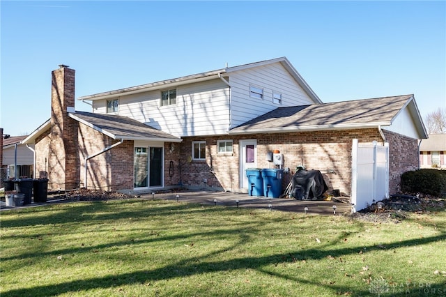 back of house with a patio area and a lawn