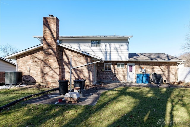 rear view of property with central AC and a yard