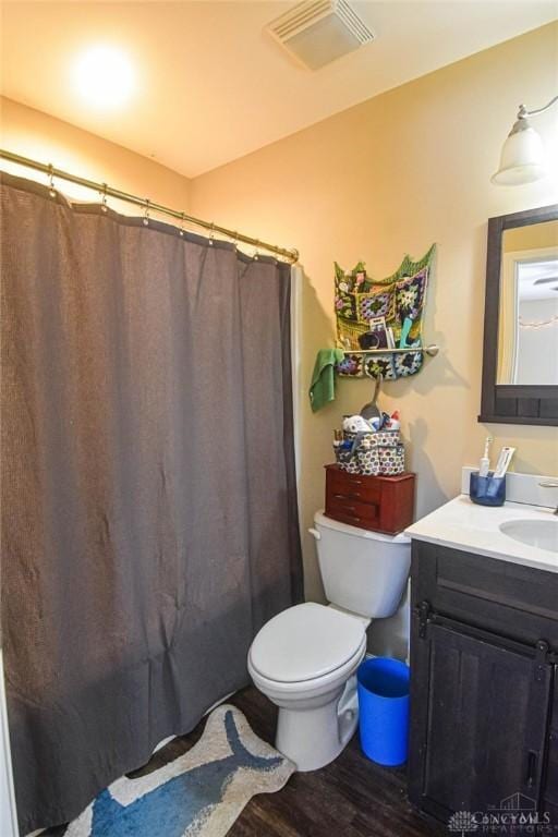 bathroom featuring hardwood / wood-style floors, toilet, curtained shower, and vanity