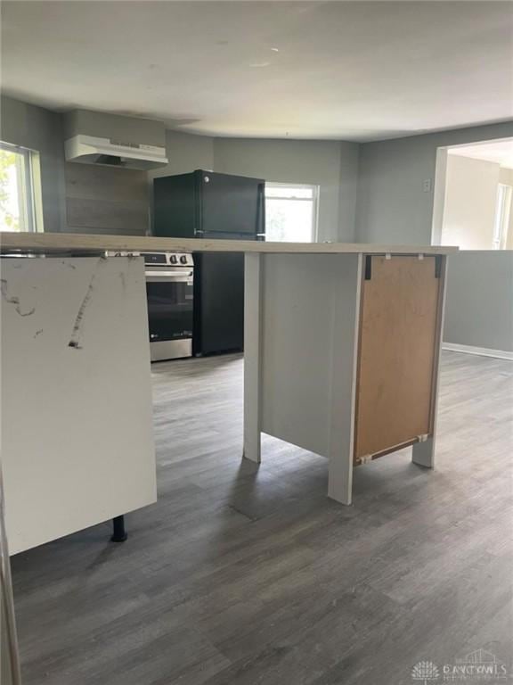 kitchen featuring hardwood / wood-style flooring, a center island, and wall oven