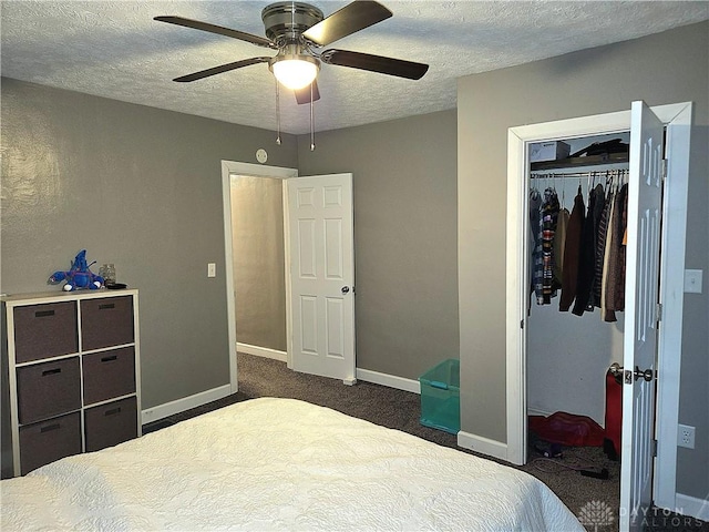 bedroom featuring dark colored carpet, a textured ceiling, ceiling fan, and a closet