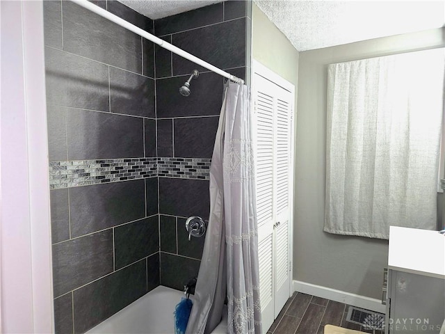 bathroom featuring shower / bathtub combination with curtain, vanity, and a textured ceiling