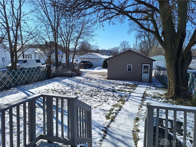 snowy yard featuring an outdoor structure and a deck