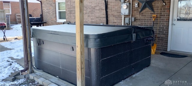 details featuring brick siding, electric meter, and a jacuzzi